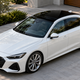 AI-generated concept of a white sedan with a glossy black roof wrap